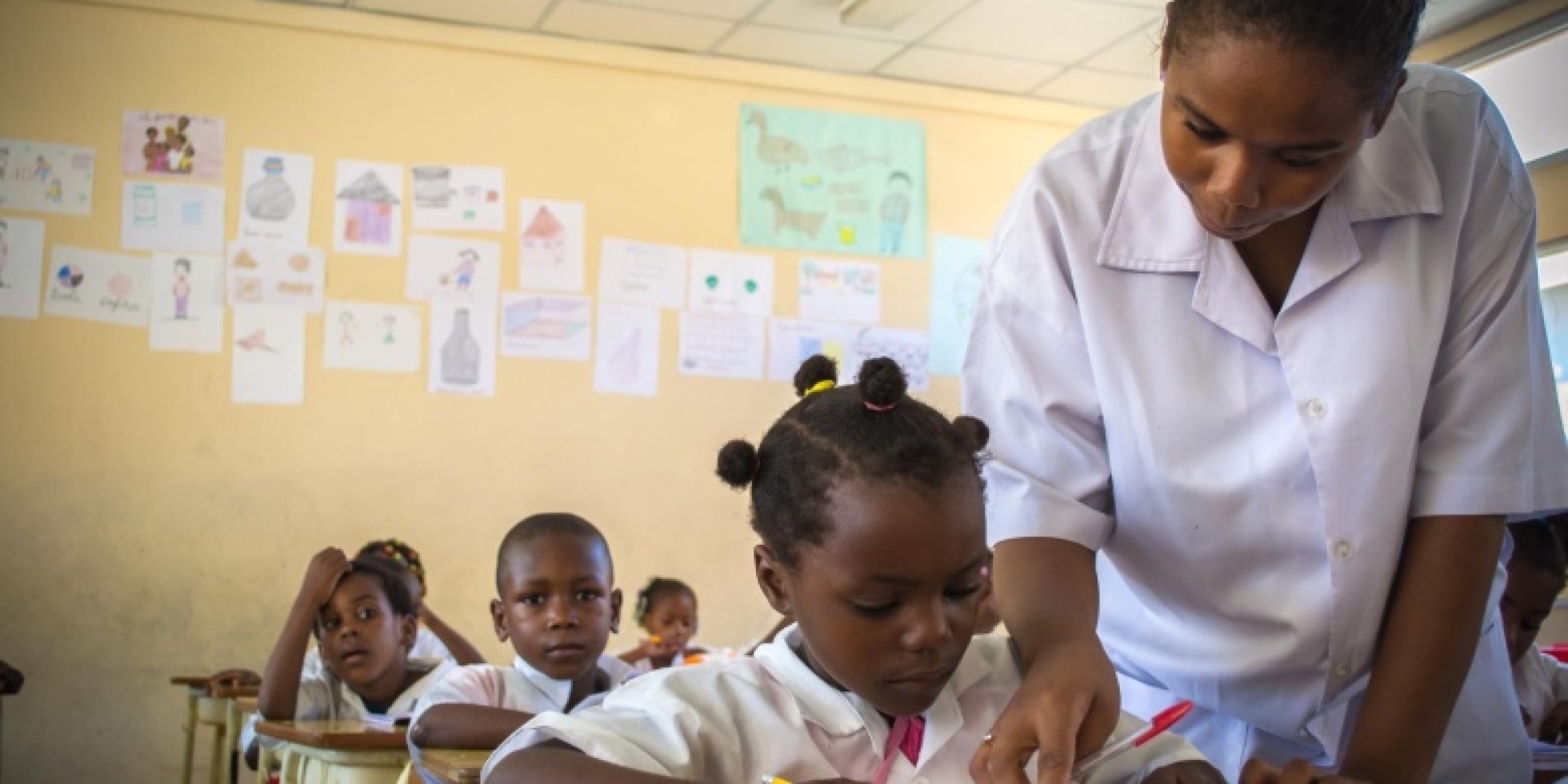A teacher correcting the work of one of her students in class. Credit: UNICEF Angola/2014/Federica Polselli